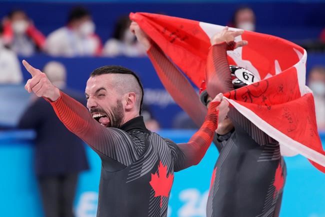 Charles Hamelin (6) of Canada reacts with teammate Jordan Pierre Gilles after winning gold in the men's 5,000-metre short-track speedskating relay final at the Beijing Winter Olympics in Beijing, China, on Wednesday, Feb. 16, 2022. THE CANADIAN PRESS/Paul Chiasson