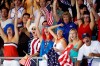 FILE - Fans cheer after a United States goal during their semifinal win over Serbia to advance to the gold medal match in the men's water polo at the Beijing 2008 Olympics in Beijing, Friday, Aug. 22, 2008. The Olympics are back in town 14 years later, but the atmosphere is much more subdued. Only a select few can watch the competitions in person because of the pandemic, and the 15,000 athletes, officials and others who have come for the Games have been kept completely separated from the population of Beijing. (AP Photo/Robert F. Bukaty, File)