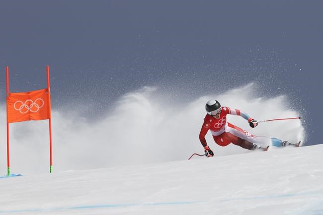 Michelle Gisin of Switzerland makes a turn during the women's combined downhill at the 2022 Winter Olympics, Thursday, Feb. 17, 2022, in the Yanqing district of Beijing. (AP Photo/Alessandro Trovati)