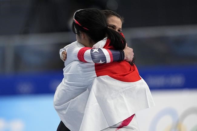 Gold medal winner Miho Takagi of Japan hugs bronze medalist Brittany Bowe of the United States, facing right, after the women's speedskating 1,000-meter finals at the 2022 Winter Olympics, Thursday, Feb. 17, 2022, in Beijing. (AP Photo/Ashley Landis)
