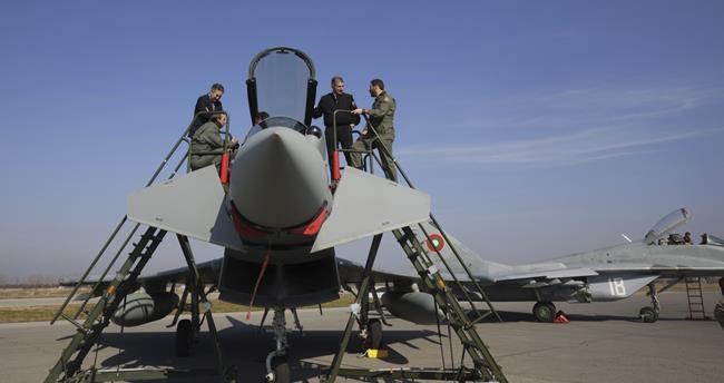 A Bulgarian air-force military officers are taking a look at Eurofighter EF-2000 Typhoon II cockpit helped by theirSpanish colleagues in Graf Ignatievo, Thursday, Feb. 17, 2022.. As part of the united efforts of NATO partners to bolster the defense of the Alliance's eastern flank while tensions are continuing over a possible Russian invasion in Ukraine, Spain is sending fighter jets to Bulgaria to implement joint air policing missions. (AP Photo/Valentina Petrova)
