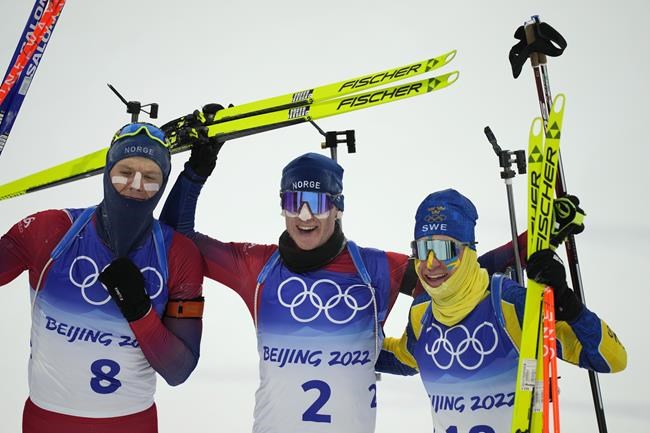 Vetle Sjaastad Christiansen of Norway (8), Johannes Thingnes Boe of Norway (2) and Martin Ponsiluoma of Sweden pose after the men's 15-kilometer mass start biathlon at the 2022 Winter Olympics, Friday, Feb. 18, 2022, in Zhangjiakou, China. (AP Photo/Frank Augstein)