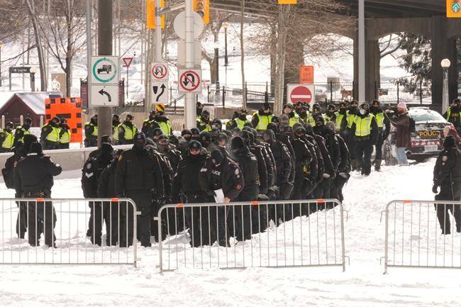 Police officers gather near the site of a trucker blockade in Ottawa, Friday, Feb. 18, 2022. THE CANADIAN PRESS/Adrian Wyld