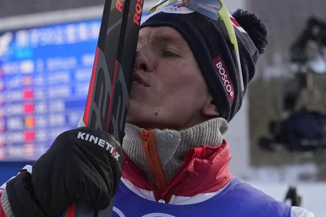 Gold medal finisher Russian athlete Alexander Bolshunov reacts during a venue ceremony after the men's weather-shortened 50km mass start free cross-country skiing competition at the 2022 Winter Olympics, Saturday, Feb. 19, 2022, in Zhangjiakou, China. (AP Photo/Aaron Favila)