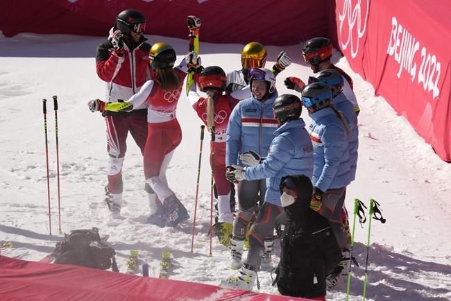Team Austria, left, celebrate after winning the gold medal race of the mixed team parallel skiing event at the 2022 Winter Olympics, Sunday, Feb. 20, 2022, in the Yanqing district of Beijing. (AP Photo/Luca Bruno)