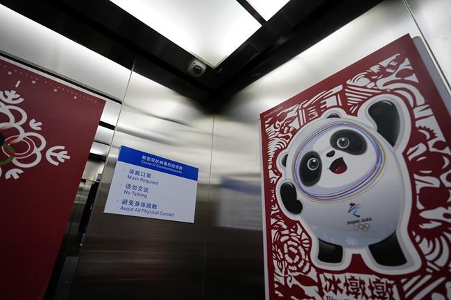 Inside an elevator shows a poster of Bing Dwen Dwen, the Beijing Winter Olympics mascot and a camera at the curling venue ahead of the Beijing Winter Olympics Tuesday, Feb. 1, 2022, in Beijing. (AP Photo/Brynn Anderson)