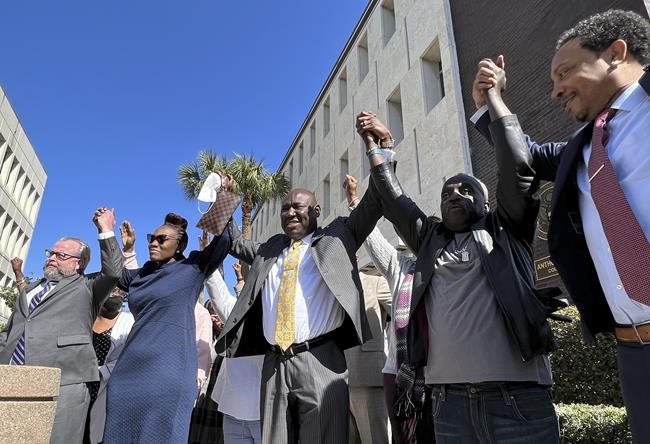 The family and attorneys of the Ahmaud Aubery raise their arms in victory after all three men were found guilty of hates crimes at the federal courthouse in Brunswick, Ga., on Tuesday, Feb. 22, 2022. Greg McMichael, Travis McMichael and William “Roddie” Bryan, the three men convicted of murder in Arbery’s fatal shooting have been found guilty of federal hate crimes. (AP Photo/Lewis M. Levine)