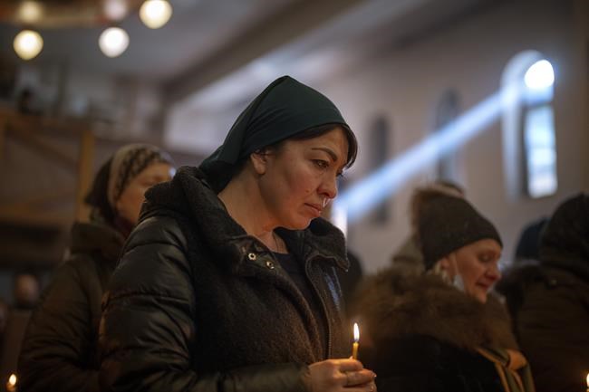 Women pray in Kyiv, during the funeral of army captain Anton Sydorov, 35, killed in eastern Ukraine, on Tuesday, Feb. 22, 2022. Western leaders said Tuesday that Russian troops have moved into rebel-held areas in eastern Ukraine after President Vladimir Putin's recognized their independence — but some indicated it was not yet the long-feared full-fledged invasion as confusion reigned in the region. (AP Photo/Emilio Morenatti)