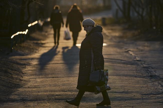 A woman walks in Sievierodonetsk, the Luhansk region, eastern Ukraine, Wednesday, Feb. 23, 2022. Ukraine urged its citizens to leave Russia, and Europe braced for further confrontation Wednesday after tensions escalated dramatically when Russia's leader received authorization to use military force outside his country and the West responded with a raft of sanctions.(AP Photo/Vadim Ghirda)