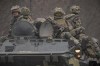 Ukrainian servicemen sit atop armored personnel carriers driving on a road in the Donetsk region, eastern Ukraine, Thursday, Feb. 24, 2022. THE CANADIAN PRESS/AP/Vadim Ghirda