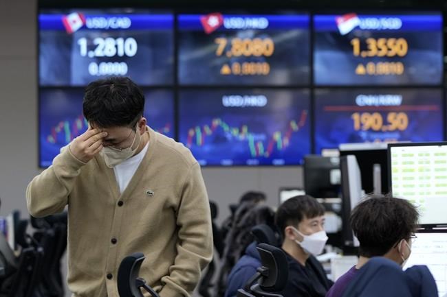 A currency trader holds his head at the foreign exchange dealing room of the KEB Hana Bank headquarters in Seoul, South Korea, Friday, Feb. 25, 2022. Asian shares rose Friday after U.S. stocks recovered toward the end of a wild trading day, as the world, including President Joe Biden, slapped sanctions against Russia for its invasion of Ukraine. (AP Photo/Ahn Young-joon)
