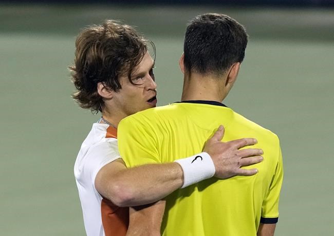 Russia's Andrey Rublev, left, comforts Poland's Hubert Hurkacz, after he beats him during a semifinal match of the Dubai Duty Free Tennis Championship in Dubai, United Arab Emirates, Friday, Feb. 25, 2022. (AP Photo/Kamran Jebreili)