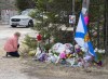 A woman pays her repects at a roadblock in Portapique, N.S. on Wednesday, April 22, 2020. Witnesses noticed the odd actions of what appeared to be an RCMP cruiser late on April 18, 2020, not realizing the driver was responsible for a murderous rampage that had just left 13 people dead in Portapique. THE CANADIAN PRESS/Andrew Vaughan