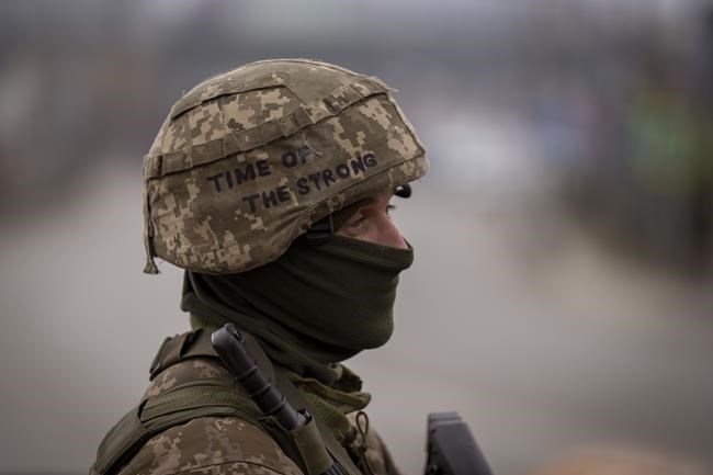 A Ukrainian soldier stands guard at a checkpoint on the outskirts of Kyiv, Ukraine, Monday, March 7, 2022. Russia announced yet another cease-fire and a handful of humanitarian corridors to allow civilians to flee Ukraine. Previous such measures have fallen apart and Moscow's armed forces continued to pummel some Ukrainian cities with rockets Monday. (AP Photo/Emilio Morenatti)