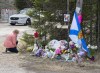 A woman pays her respects at a roadblock in Portapique, N.S. on Wednesday, April 22, 2020. THE CANADIAN PRESS/Andrew Vaughan