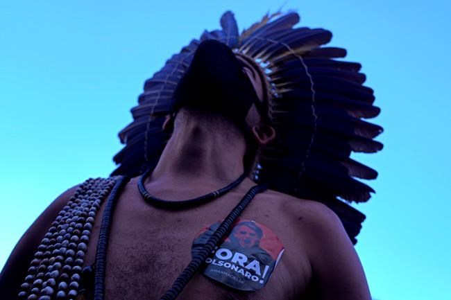 An indigenous Pataxo man with a sticker on his chest that reads in Portuguese