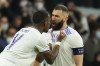 Real Madrid's David Alaba celebrates with Karim Benzema, right, who scored his side's first goal during the Champions League, round of 16, second leg soccer match between Real Madrid and Paris Saint-Germain at the Santiago Bernabeu stadium in Madrid, Spain, Wednesday, March 9, 2022. (AP Photo/Manu Fernandez)