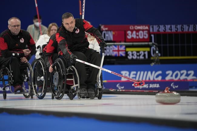 Canada's Mark Ideson pushes a stone as he and his teammates play against Norway during their wheelchair curling competition at the 2022 Winter Paralympics, Thursday, March 10, 2022, in Beijing. (AP Photo/Dita Alangkara)