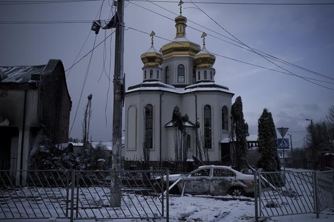 FILE - A destroyed car is parked in front of a damaged church in Irpin, on the outskirts of Kyiv, Ukraine, Tuesday, March 8, 2022. (AP Photo/Felipe Dana)