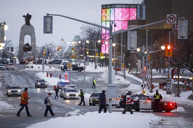 Police work a checkpoint after authorities took action to clear a trucker protest that was aimed at COVID-19 measures before growing into a broader anti-government protest and occupation, in Ottawa, Sunday, Feb. 20, 2022. The federal government has announced funding for businesses in Ottawa impacted by the protest convoy that seized the city's downtown for more than three weeks. THE CANADIAN PRESS/Cole Burston