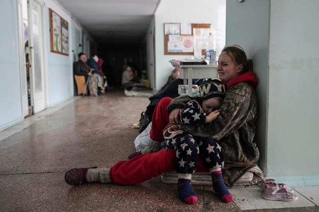Anastasia Erashova cries as she hugs her child in a corridor of a hospital in Mariupol, eastern Ukraine on Friday, March 11, 2022. Anastasia's other child was killed during the shelling of Mariupol. (AP Photo/Evgeniy Maloletka)
