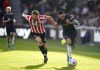 Brentford's Kristoffer Ajer, left, and Burnley's Dwight McNeil battle for the ball during the English Premier League soccer match between Brentford and Burnley at Brentford Community Stadium, London, Saturday March 12, 2022. (John Walton/PA via AP)