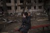 A resident sits outside a destroyed building after it was hit by artillery shelling in Kyiv, Ukraine, Monday, March 14, 2022. (AP Photo/Felipe Dana)