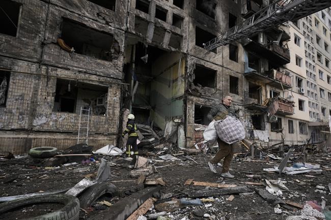 A local resident searches for his belongings in an apartment building after it was hit by artillery shelling in Kyiv, Ukraine, Monday, March 14, 2022. (AP Photo/Vadim Ghirda)