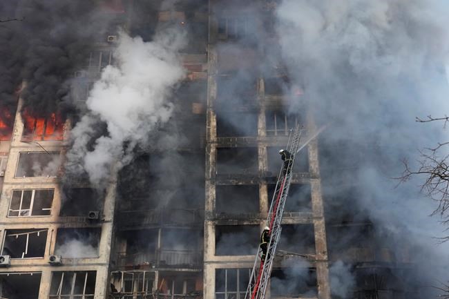 Firefighters work in an apartment building damaged by shelling in Kyiv, Ukraine, Tuesday, March 15, 2022. (AP Photo/Efrem Lukatsky)