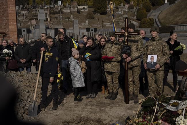 Relatives and friends attend the funeral of Ukrainian military servicemen Rostyslav Romanchuk in Lviv, Ukraine, Tuesday, March 15, 2022. Romanchuk was killed during Sunday's Russian missile strike on a military training base near Ukraine's western border with NATO member Poland. (AP Photo/Bernat Armangue)