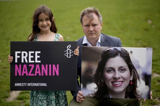 FILE - Richard Ratcliffe, the husband of imprisoned British-Iranian Nazanin Zaghari-Ratcliffe and their seven year old daughter Gabriella pose for the media in Parliament Square, London, to mark the 2,000 days she has been detained in Iran, Thursday, Sept. 23, 2021. British lawmaker, Tulip Siddiq, said Wednesday March 16, 2022 that Nazanin Zaghari-Ratcliffe, who has been detained in Iran for nearly six years, is on her way to Tehran's airport to leave the country. (AP Photo/Matt Dunham, File)