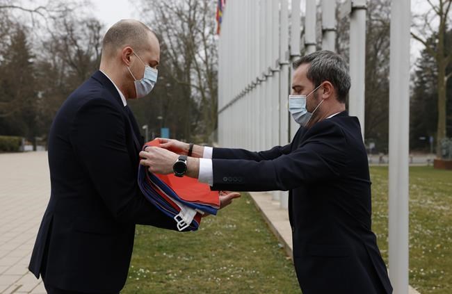 Employees of the Council of Europe fold the Russian flag after it was removed from the Council of Europe building, Wednesday, March 16, 2022 in Strasbourg. The Council of Europe expelled Russia from the continent's foremost human rights body in an unprecedented move over its invasion and war in Ukraine. The 47-nation organization's committee of ministers said in statement that