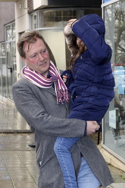Richard Ratcliffe, with his daughter Gabriella, pose for the media outside of their home ahead of his wife Nazanin Zaghari-Ratcliffe's return, in London, Wednesday, March 16, 2022. Zaghari-Ratcliffe, a British charity worker who has been detained in Iran for almost six years, is flying home from Tehran after the U.K. government settled a decades-old debt to Iran. Zaghari-Ratcliffe and another dual national, Anoush Ashoori, who was detained in Tehran in 2017, boarded a plane from Tehran’s Mehrabad International Airport after the deal was struck. (PA via AP)