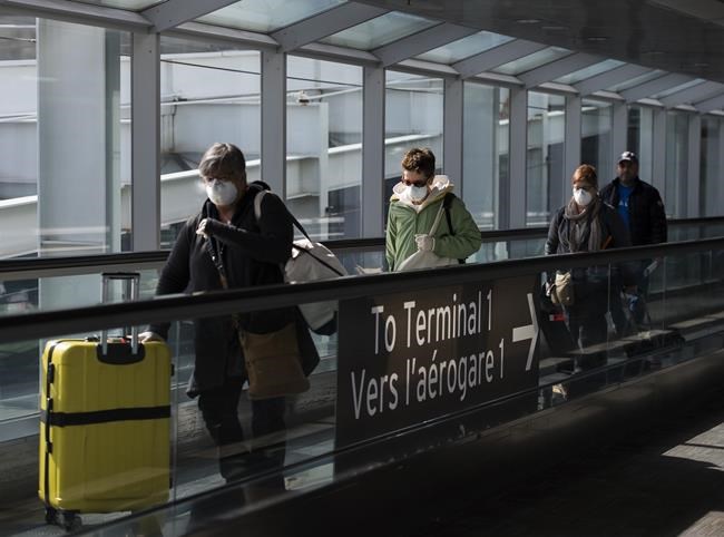 People leave the terminal after arriving at Pearson International Airport in Toronto on Monday, March 16, 2020. Vaccinated travellers will no longer require a negative COVID-19 test to come to Canada, according to a source in the federal government.THE CANADIAN PRESS/Nathan Denette