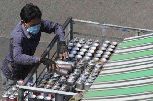 FILE - A vendor prepares gas bottles for local customers in Phnom Penh, Cambodia, Wednesday, March 9, 2022. Cambodia on Thursday, March 17, announced new measures that significantly ease pandemic-related restrictions for foreign visitors, including dropping mandatory COVID-19 tests for travelers who have been vaccinated. (AP Photo/Heng Sinith, File)
