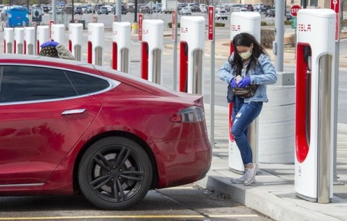 Sky-high gas prices are pushing electric vehicles (EVs) further into the spotlight as of late, as more drivers think seriously about going electric. A woman prepares to plug in her EV in Markham, Ontario on Wednesday April 15, 2020. THE CANADIAN PRESS/Frank Gunn