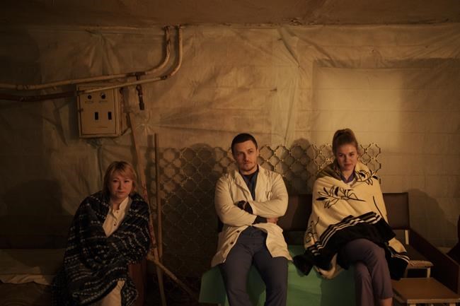 Medical staff sit in a hospital basement, used as a bomb shelter, during an air raid alarm in Brovary, north of Kyiv, Ukraine, Thursday, March 17, 2022. (AP Photo/Felipe Dana)
