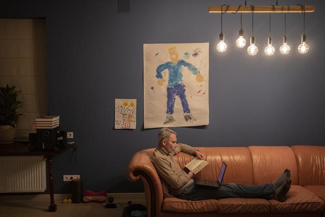 Ukrainian entrepreneur Yevhen Potoplyak, 42, reads a story to his sons Ostab and Denys via videoconference in Lviv, western Ukraine, Thursday, March 17, 2022. Yevhen's two sons and his wife Maria left for Poland on Feb. 26. (AP Photo/Bernat Armangue)