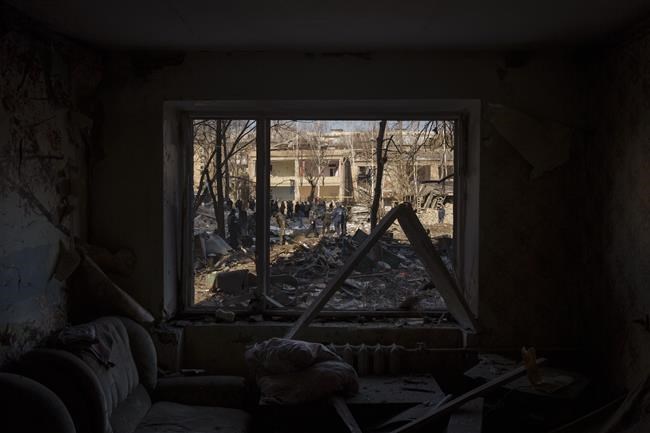 Ukrainian soldiers and Police officers inspect the site of a bombing near a residential buildings in Kyiv, Ukraine, Friday, March 18, 2022. Russian forces pressed their assault on Ukrainian cities Friday, with new missile strikes and shelling on the edges of the capital Kyiv and the western city of Lviv, as world leaders pushed for an investigation of the Kremlin’s repeated attacks on civilian targets, including schools, hospitals and residential areas. (AP Photo/Felipe Dana)