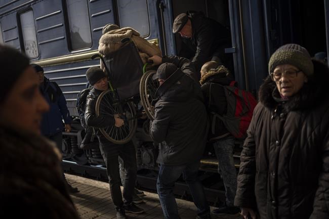 Ukrainians escaping from the besieged city of Mariupol along with other passengers from Zaporizhzhia arrive at Lviv, western Ukraine, on Sunday, March 20, 2022. (AP Photo/Bernat Armangue)
