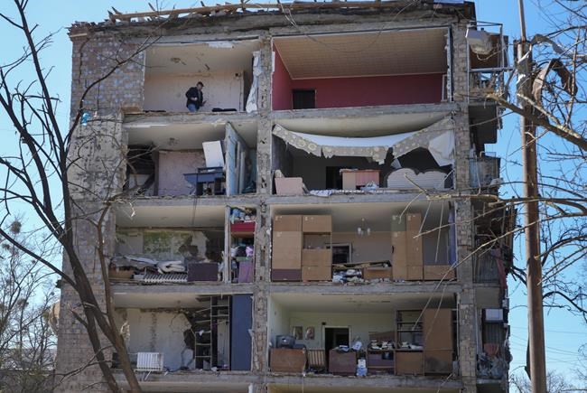 A man walks in his apartment ruined after the Russian shelling in Kyiv, Ukraine, Monday, March 21, 2022. At least eight people were killed in the attack. (AP Photo/Efrem Lukatsky)