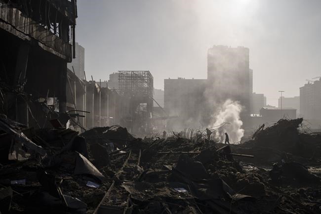 Firefighters extinguish a fire near a shopping center after shelling, in Kyiv, Ukraine, Monday, March 21, 2022. (AP Photo/Felipe Dana)