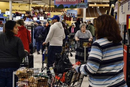 FILE - Shoppers wait in lines to check out at a Ralphs supermarket on March 13, 2020, in the Panorama City section of Los Angeles. Thousands of southern and central California grocery workers began voting, Monday, March 21, 2022, on whether to authorize their union to call a strike against several major supermarket chains. (AP Photo/Richard Vogel, File)
