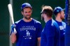 Los Angeles Dodgers' Chris Taylor, left, talks with Max Muncy as they take batting practice during a spring training baseball workout Sunday, March 13, 2022, in Phoenix. (AP Photo/Ross D. Franklin)