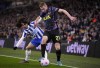 Tottenham's Dejan Kulusevski, right, duels for the ball with Brighton's Marc Cucurella during the English Premier League soccer match between Brighton and Tottenham Hotspur at the Falmer stadium in Brighton, England, Wednesday, March 16, 2022. (AP Photo/Matt Dunham)