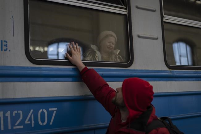 Displaced Ukrainians on a Poland-bound train bid farewell in Lviv, western Ukraine, Tuesday, March 22, 2022. The U.N. refugee agency says more than 3.5 million people have fled Ukraine since Russia's invasion, passing another milestone in an exodus that has led to Europe's worst refugee crisis since World War II. (AP Photo/Bernat Armangue)