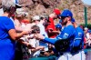 Kansas City Royals players Ryan O'Hearn, second from right, and LaCoby Jones, right, give autographs to fans prior to a spring training baseball game against the Los Angeles Angels, Monday, March 21, 2022, in Tempe, Ariz. (AP Photo/Ross D. Franklin)