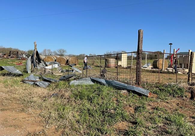 Debris lines the roads as crews and homeowners work to repair properties damaged by severe weather in Elgin, Texas, Tuesday, March 22, 2022. Officials say multiple tornadoes ripped through parts of Texas and Oklahoma on Monday. (AP Photo/Acacia Coronado)