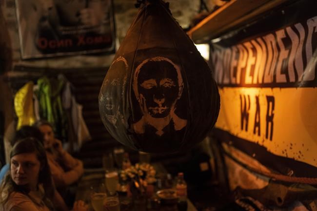 A boxing ball with a drawing of Russian President Vladimir Putin's face hangs inside a bar in downtown Lviv, western Ukraine, Tuesday, March 22, 2022. Ukrainian forces fought off continuing Russian efforts to occupy Mariupol and claimed to have retaken a strategic suburb of Kyiv on Tuesday, mounting a defense so dogged that it is stoking fears Russia's Vladimir Putin will escalate the war to new heights. (AP Photo/Bernat Armangue)
