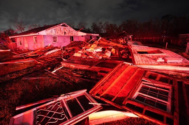 Destroyed homes, illuminated by fire engine lights, are seen after a tornado in Arabi, La., Tuesday, March 22, 2022. A tornado tore through parts of New Orleans and its suburbs Tuesday night, ripping down power lines and scattering debris in a part of the city that had been heavily damaged by Hurricane Katrina 17 years ago. (AP Photo/Gerald Herbert)